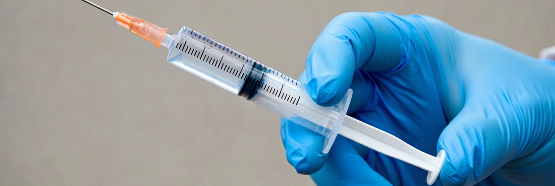Шприц в руке медика